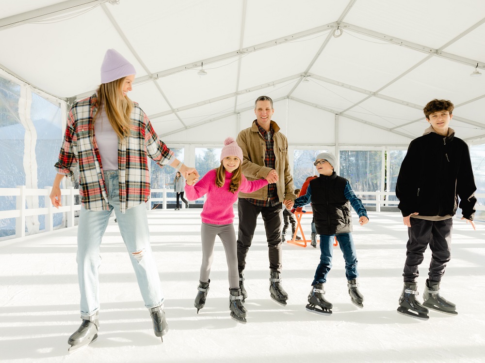 A family hand-in-hand, enjoying the ice rink, skating outside on the real ice.